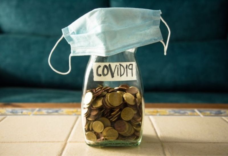 A collection of money in a jar marked "Covid-19"
